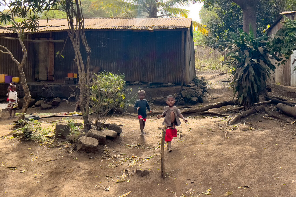 Enfants malgaches qui courent et qui font signe de la main à Madagascar.