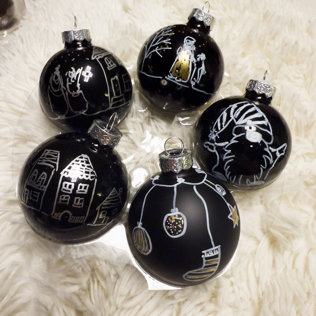 Symboles de Noël sur une boule de Noël en verre, création Atelier VADE.
boule noire brillante et mate