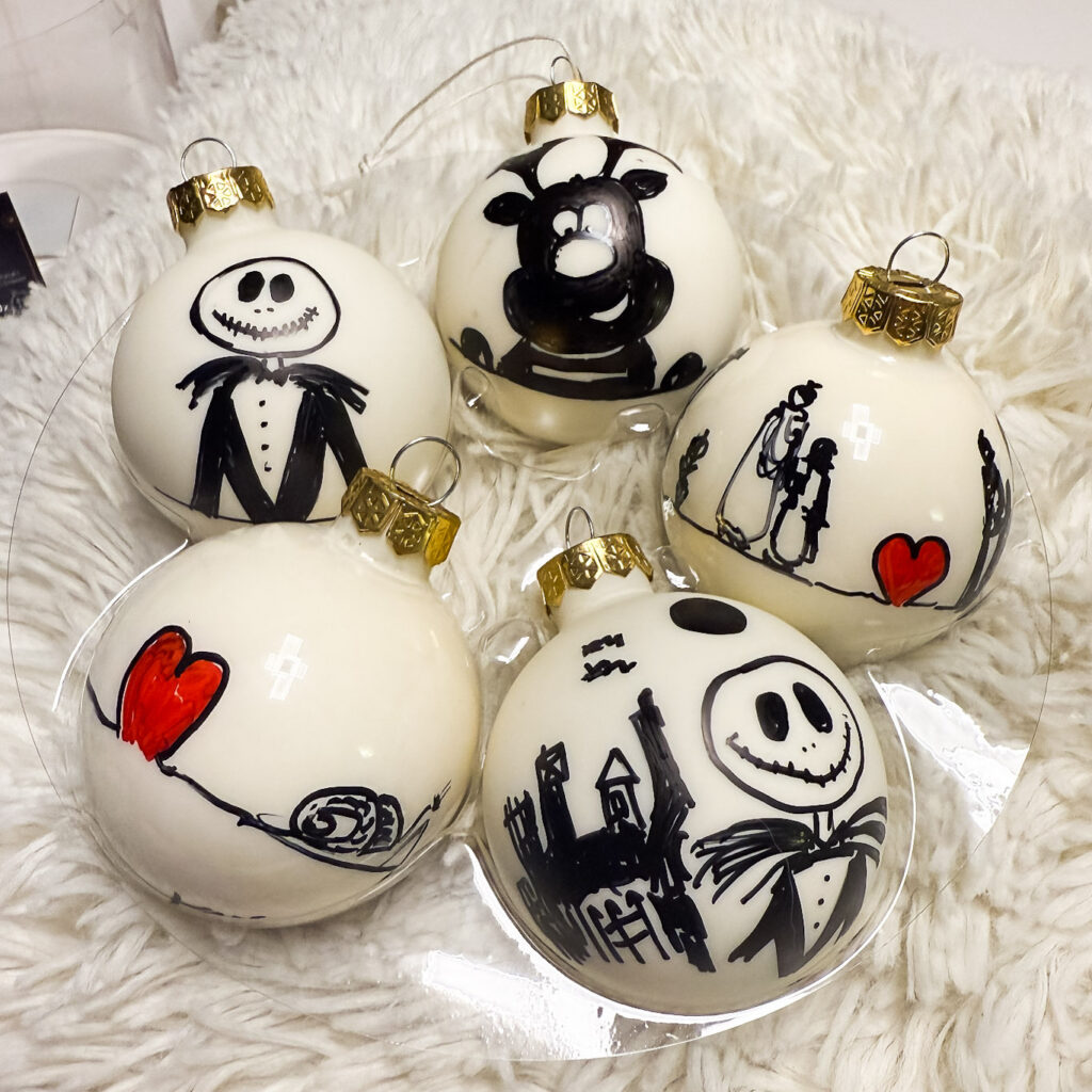 Symboles de Noël sur une boule de Noël en verre, création Atelier VADE.
boule blanc cassé brillante et mate, Monsieur Jack, coeur, escargot, renne